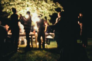 Blurry picture of a group of people in a enlighten garden during summer