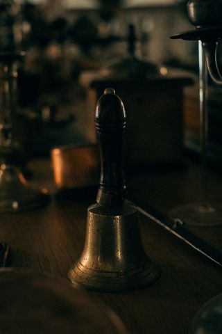Picture of a bell displayed on a sideboard full of other trinkets