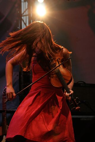 Babet playing the violin on stage