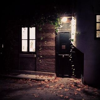 A door barely lit in a cold autumn night in Paris