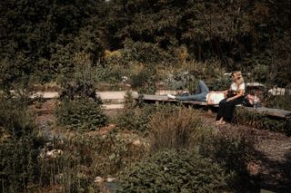 A couple relaxing on a bench in a lush garden